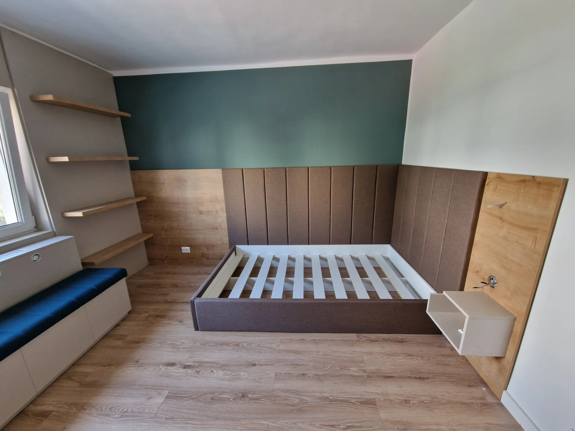 Dormitor compact cu mobilier verde, lemn și spații de depozitare