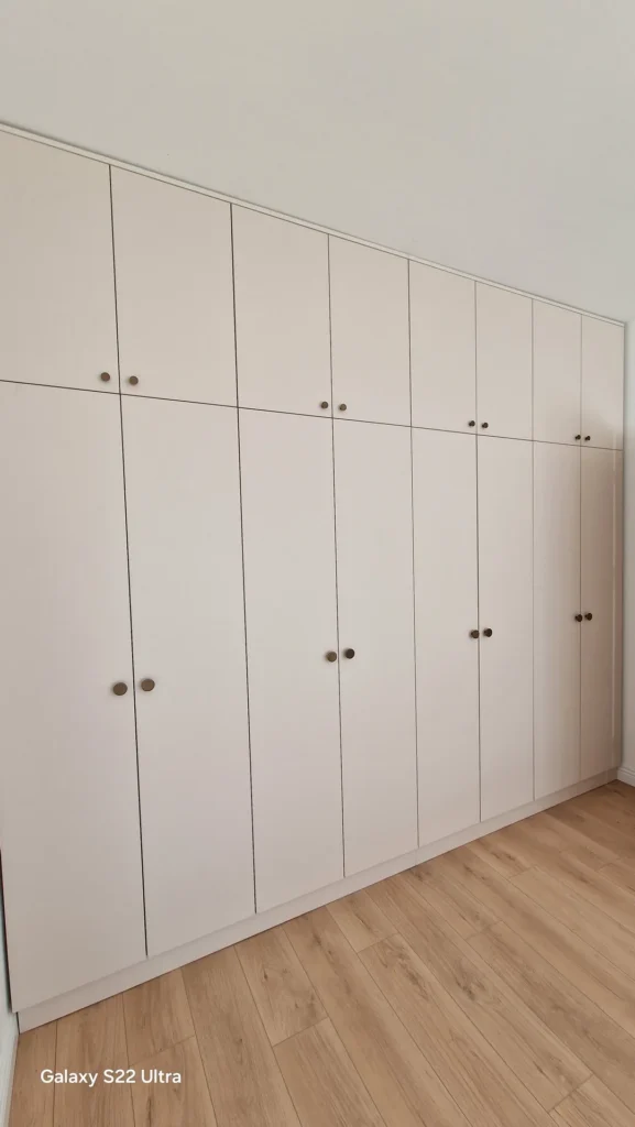 Fațada unui dressing alb realizat pe toată înălțimea camerei