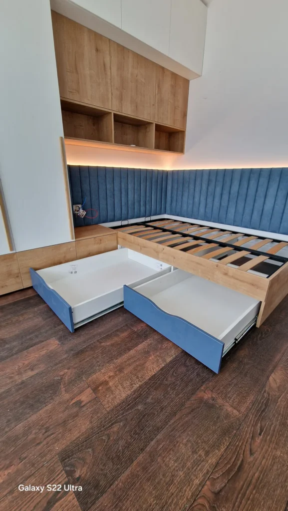 Pat tapițat albastru cu sertare de depozitare și mobilier integrat