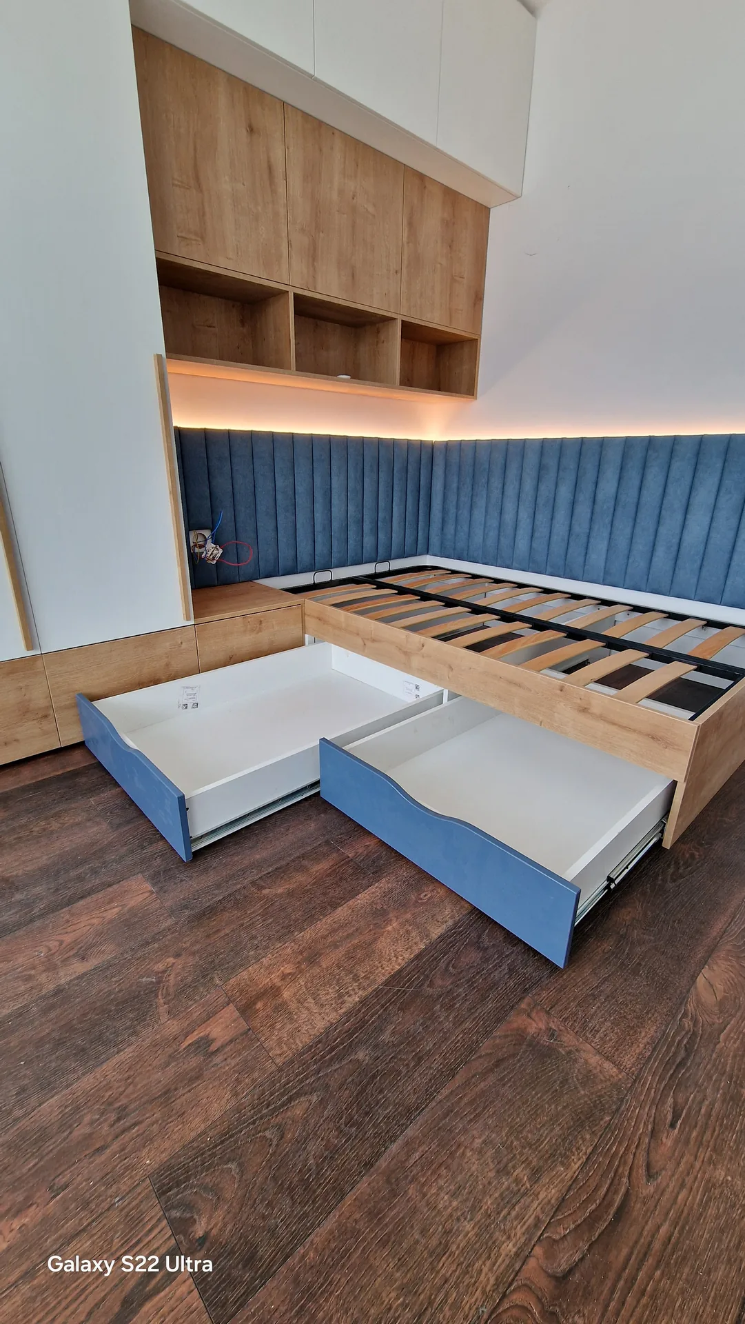 Pat tapițat albastru cu sertare de depozitare și mobilier integrat